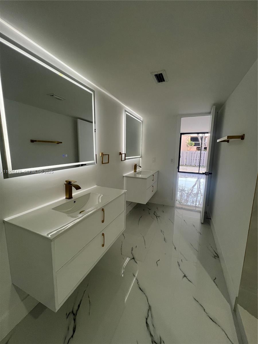 20610 Northeast 7th Court Miami, FL 33179 - Photo 17 of 38 a spacious bathroom with a double vanity sink and mirror