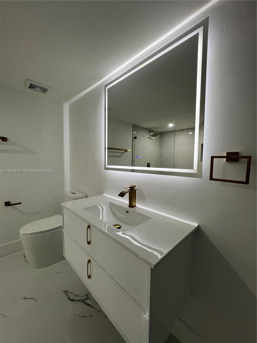 20610 Northeast 7th Court Miami, FL 33179 - Photo 18 of 38 a bathroom with a sink toilet and mirror