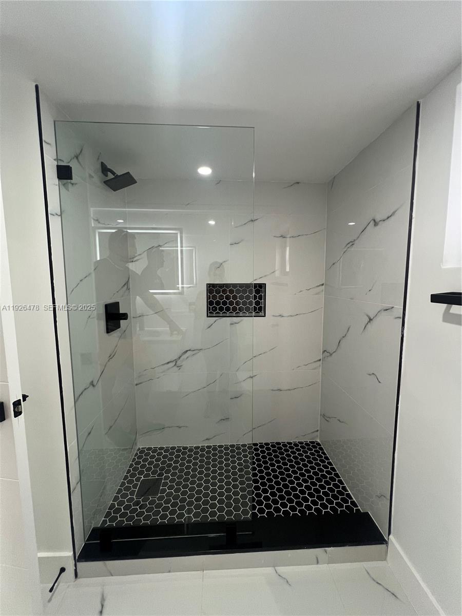 20610 Northeast 7th Court Miami, FL 33179 - Photo 19 of 38 a bathroom with a shower and a mirror