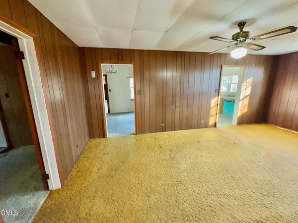 an empty room with windows and cabinet