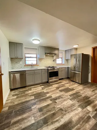 a large kitchen with a stove a sink and a refrigerator