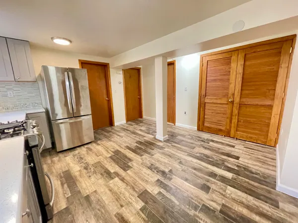 a view of a kitchen with furniture and a refrigerator