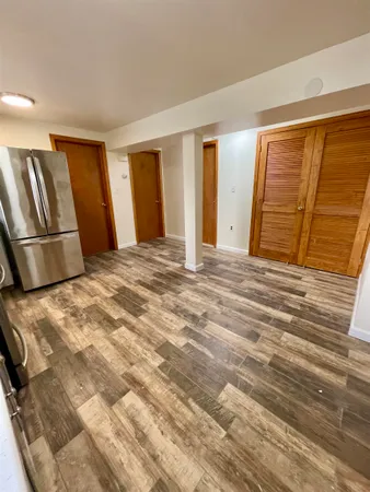 a view of empty room with wooden floor and cabinet