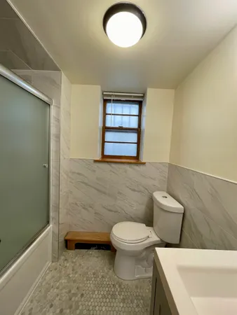a bathroom with a toilet a sink and mirror