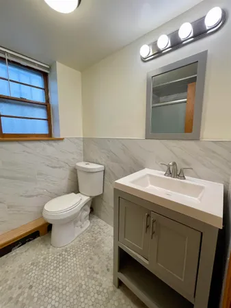a bathroom with a sink a toilet and mirror