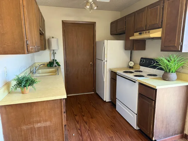 a kitchen with stainless steel appliances a sink a stove a refrigerator and cabinets