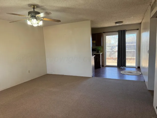 a view of a livingroom with a chandelier fan and window