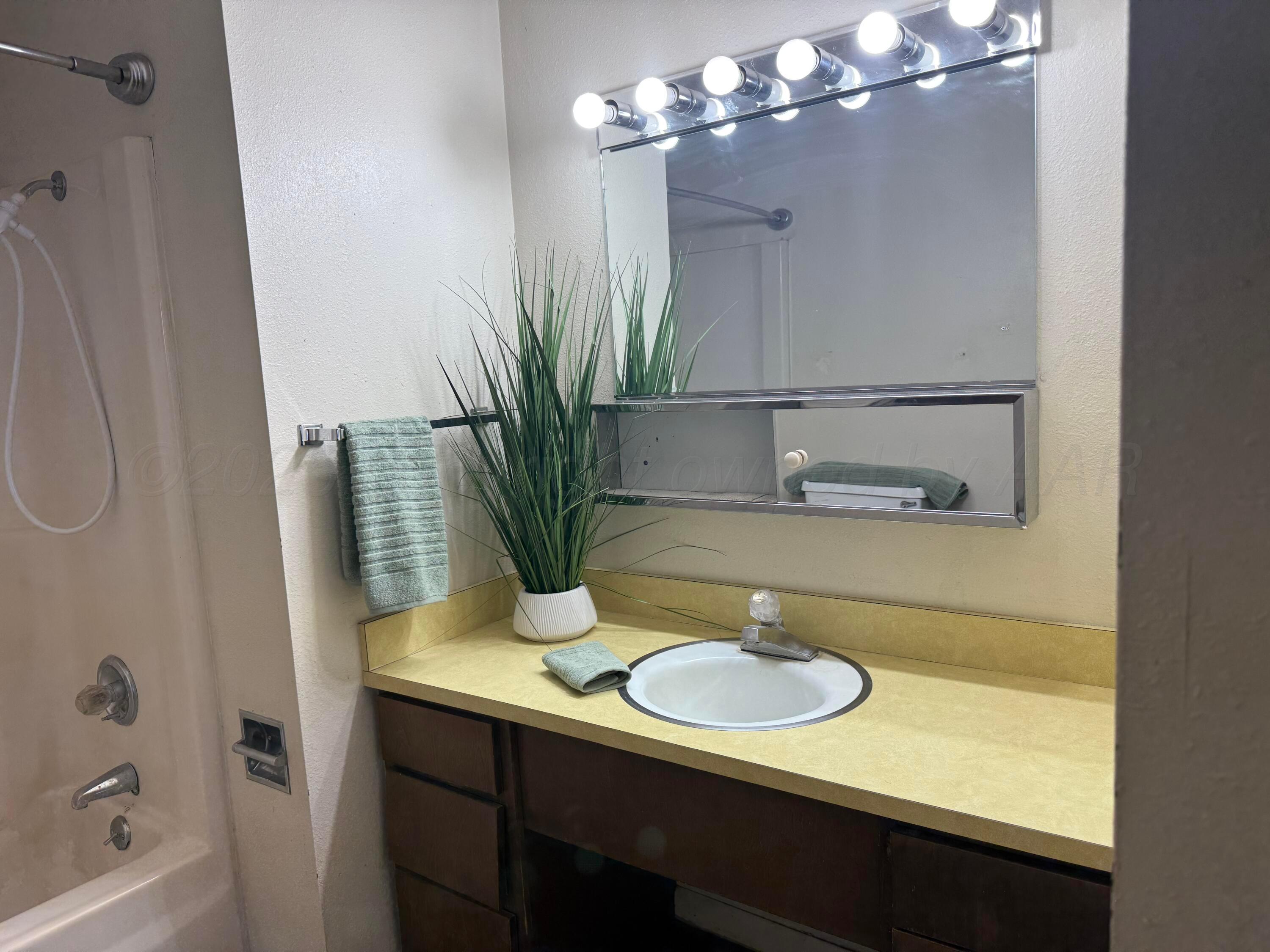 403 3rd Avenue Canyon, TX 79015 - Photo 4 of 8 a bathroom with a sink a light fixture and a mirror
