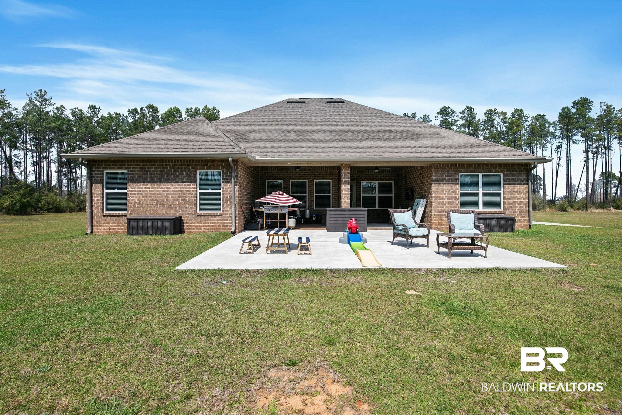 12750 B Jenkins Pit Road Daphne, AL 36527 - Photo 59 of 89 Rear view of property with a yard, a patio, a shingled roof, and brick siding