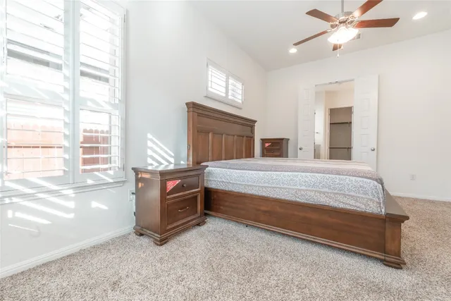 a bedroom with a bed and a large window with the outer view