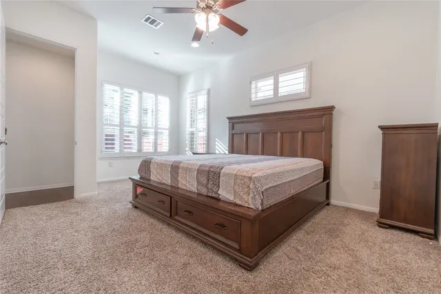 a bed sitting in a spacious bedroom next to a window