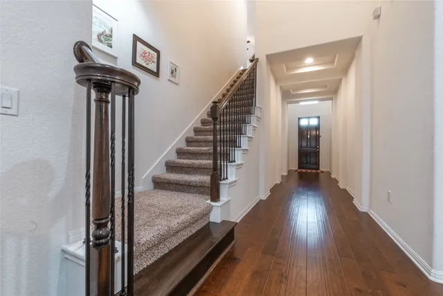 a view of a hallway with wooden floor and stairs