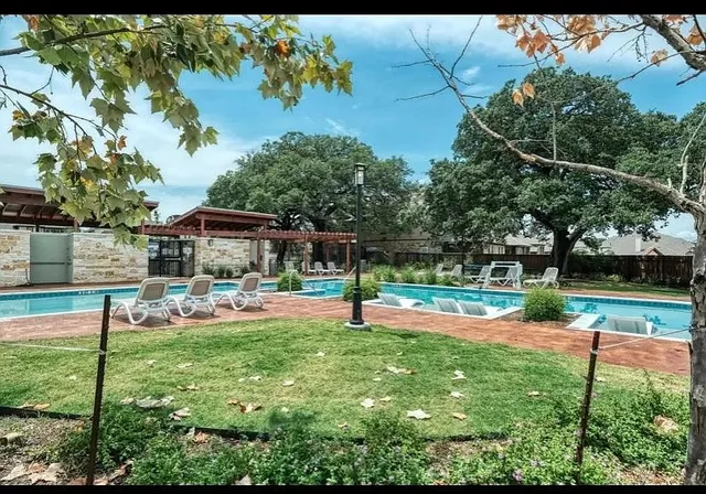 a view of swimming pool with lawn chairs and a big yard