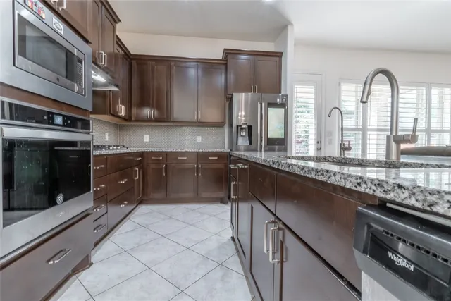 a kitchen with stainless steel appliances granite countertop a sink a stove and cabinets