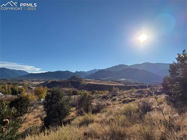 a view of mountain with sunset in background