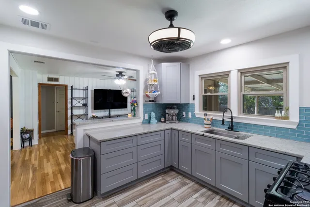 a kitchen with a sink and a stove top oven