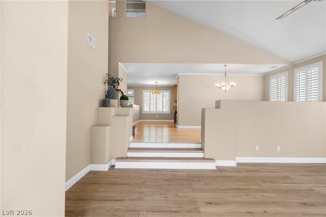 708 Vortex Avenue Henderson, NV 89002 - Photo 6 of 71 Natural light cascades through multiple windows, illuminating the tiered living spaces and warm hardwood flooring.