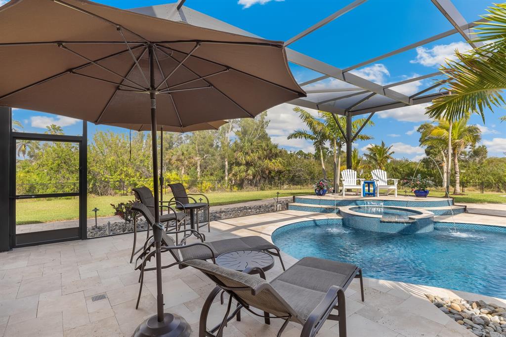 3700 Como Street Port Charlotte, FL 33948 - Photo 69 of 88 a view of a swimming pool with a table and chairs under an umbrella