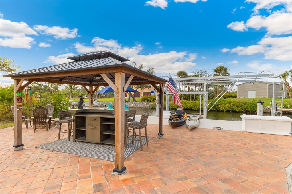 3700 Como Street Port Charlotte, FL 33948 - Photo 77 of 88 a view of a patio with a table and chairs under an umbrella