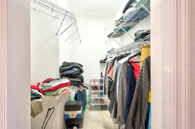 a view of walk in closet with clothes and shoes