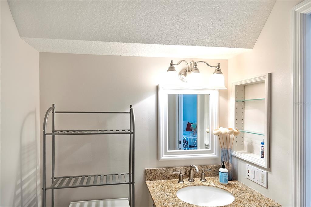 5264 Bouchard Circle, Unit 102 Sarasota, FL 34238 - Photo 13 of 32 a bathroom with a mirror sink and a mirror