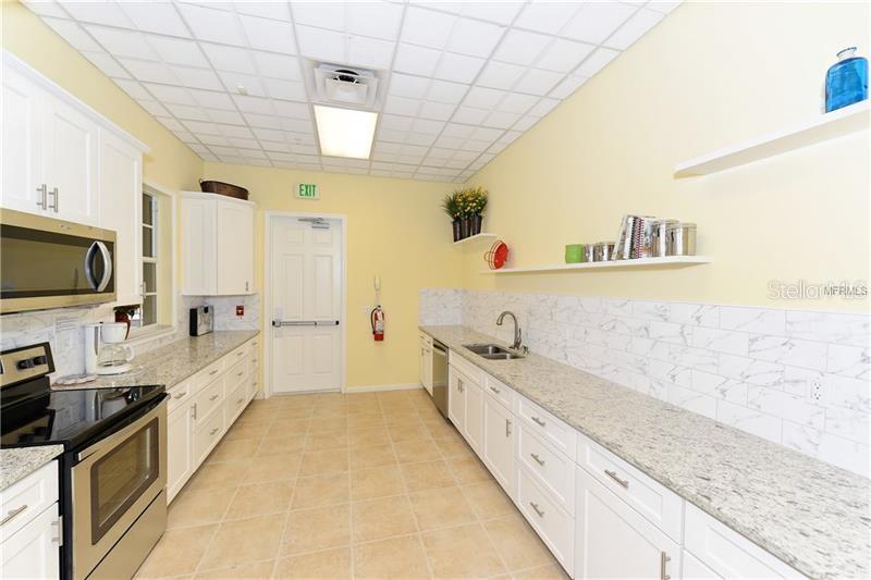 5264 Bouchard Circle, Unit 102 Sarasota, FL 34238 - Photo 30 of 32 a large kitchen with kitchen island granite countertop lots of counter top space
