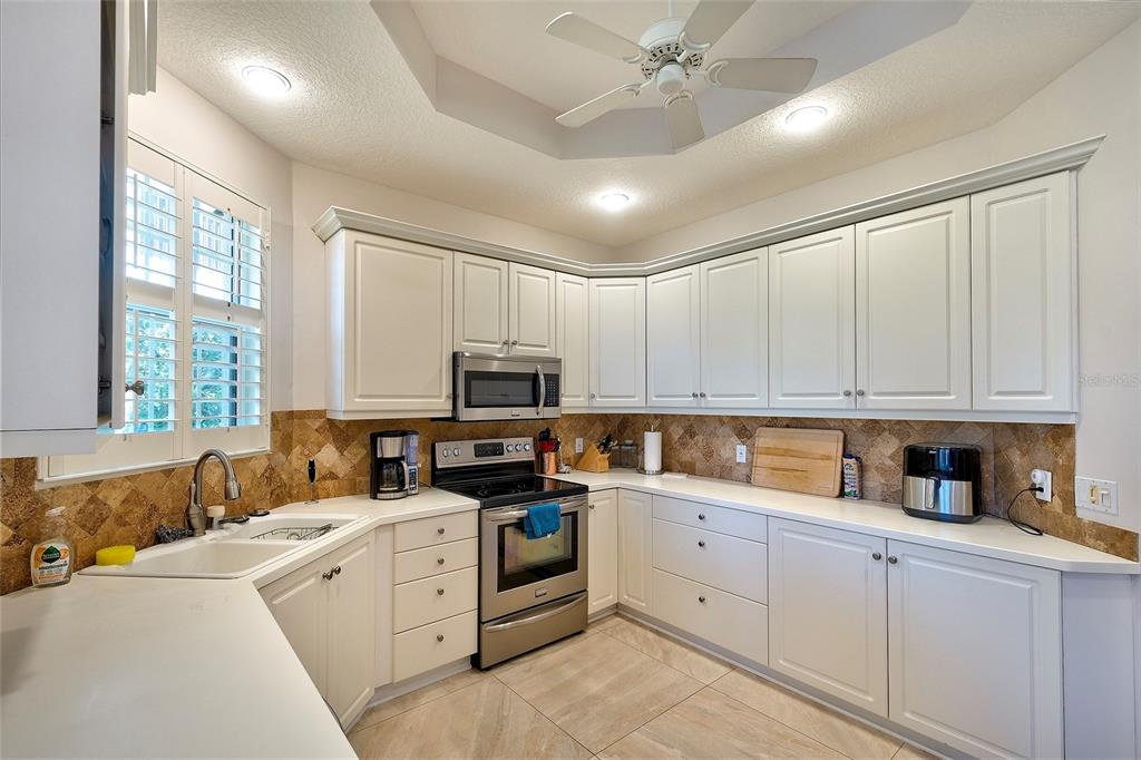 5264 Bouchard Circle, Unit 102 Sarasota, FL 34238 - Photo 3 of 32 a kitchen with cabinets stainless steel appliances a sink and a window