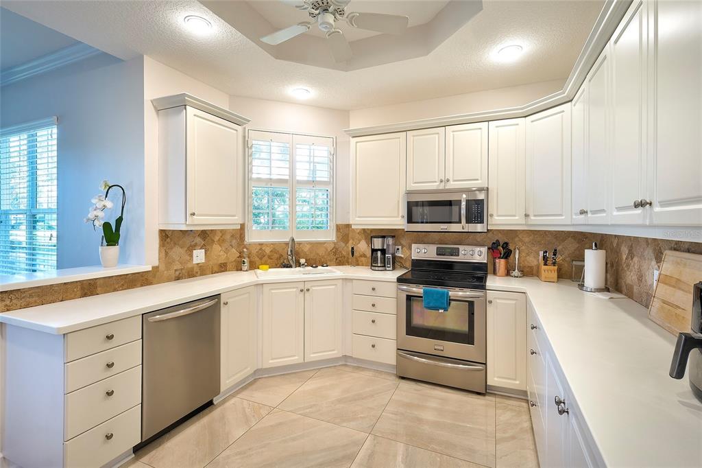 5264 Bouchard Circle, Unit 102 Sarasota, FL 34238 - Photo 4 of 32 a kitchen with stainless steel appliances a stove sink and microwave