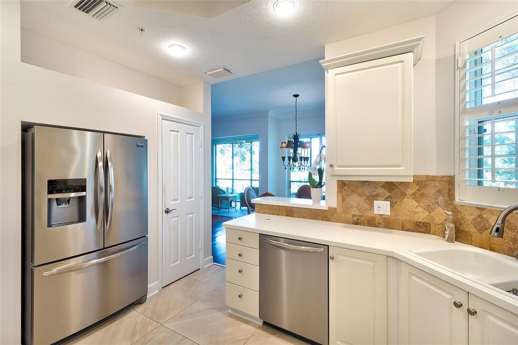 5264 Bouchard Circle, Unit 102 Sarasota, FL 34238 - Photo 5 of 32 a kitchen with stainless steel appliances a refrigerator sink and cabinets