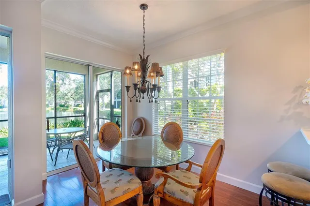 a dining room with furniture a chandelier and wooden floor