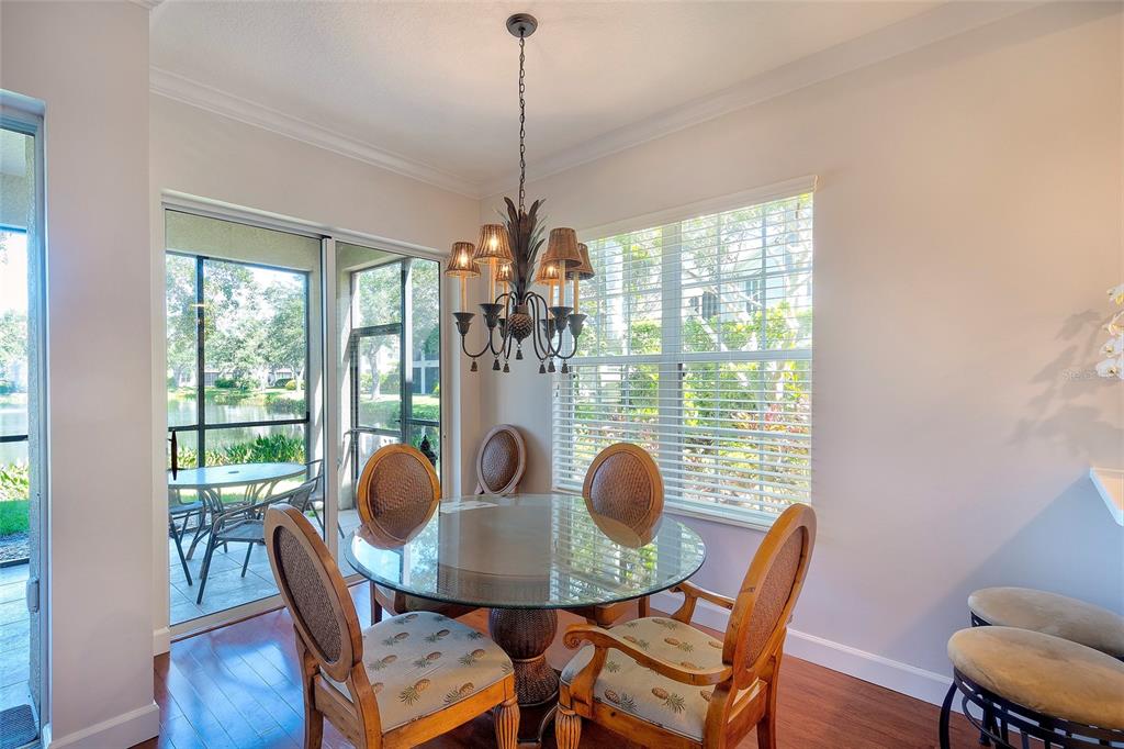 5264 Bouchard Circle, Unit 102 Sarasota, FL 34238 - Photo 6 of 32 a dining room with furniture a chandelier and wooden floor