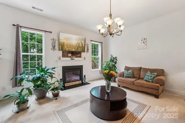 a living room with furniture a fireplace and a chandelier