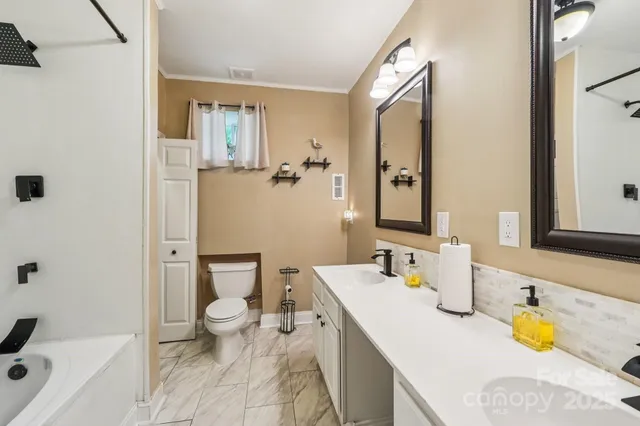 a bathroom with a granite countertop sink mirror vanity and toilet