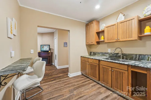 a kitchen with granite countertop a sink cabinets and wooden floor