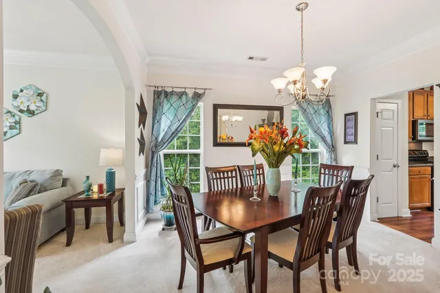 a view of a dining room with furniture and chandelier