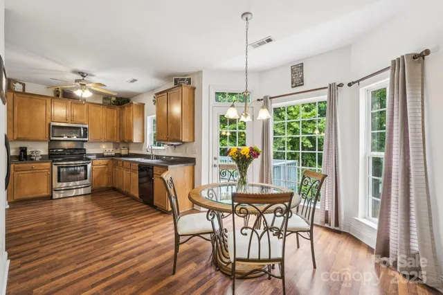 a view of a dining room and livingroom with furniture wooden floor a chandelier