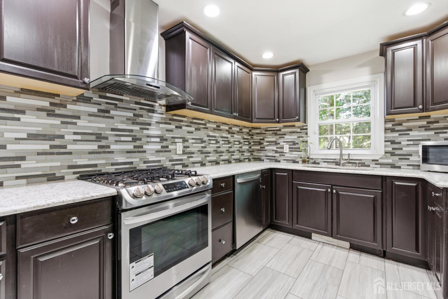 5 McKinley Street Edison, NJ 08820 - Photo 12 of 38 a kitchen with stainless steel appliances wooden cabinets stove and a sink