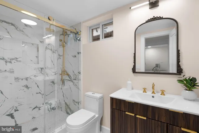 a bathroom with a sink vanity mirror and toilet