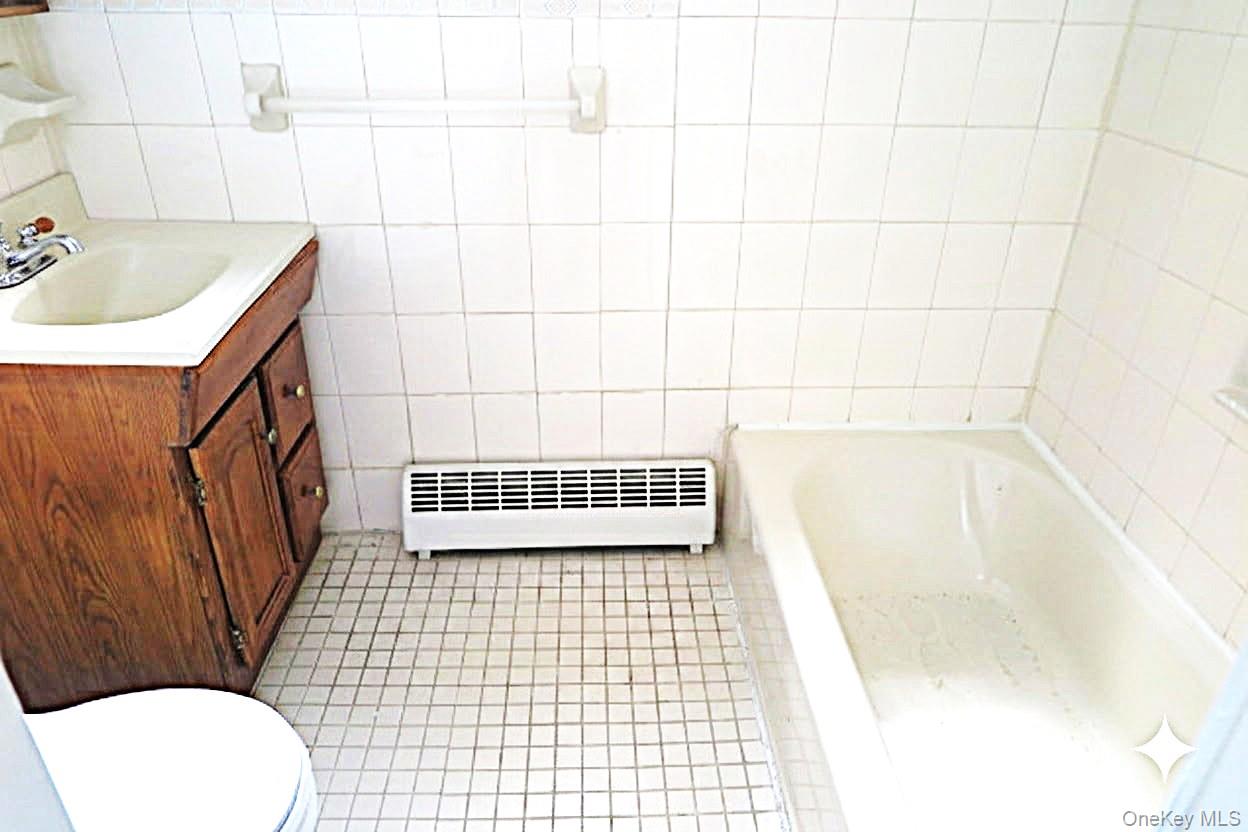 138 Spring Street Massapequa, NY 11758 - Photo 24 of 45 a bathroom with a bathtub and toilet