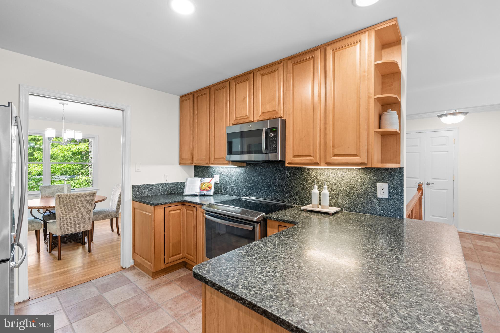 6604 Grey Fox Drive Springfield, VA 22152 - Photo 11 of 46 a kitchen with granite countertop a stove a sink and a microwave