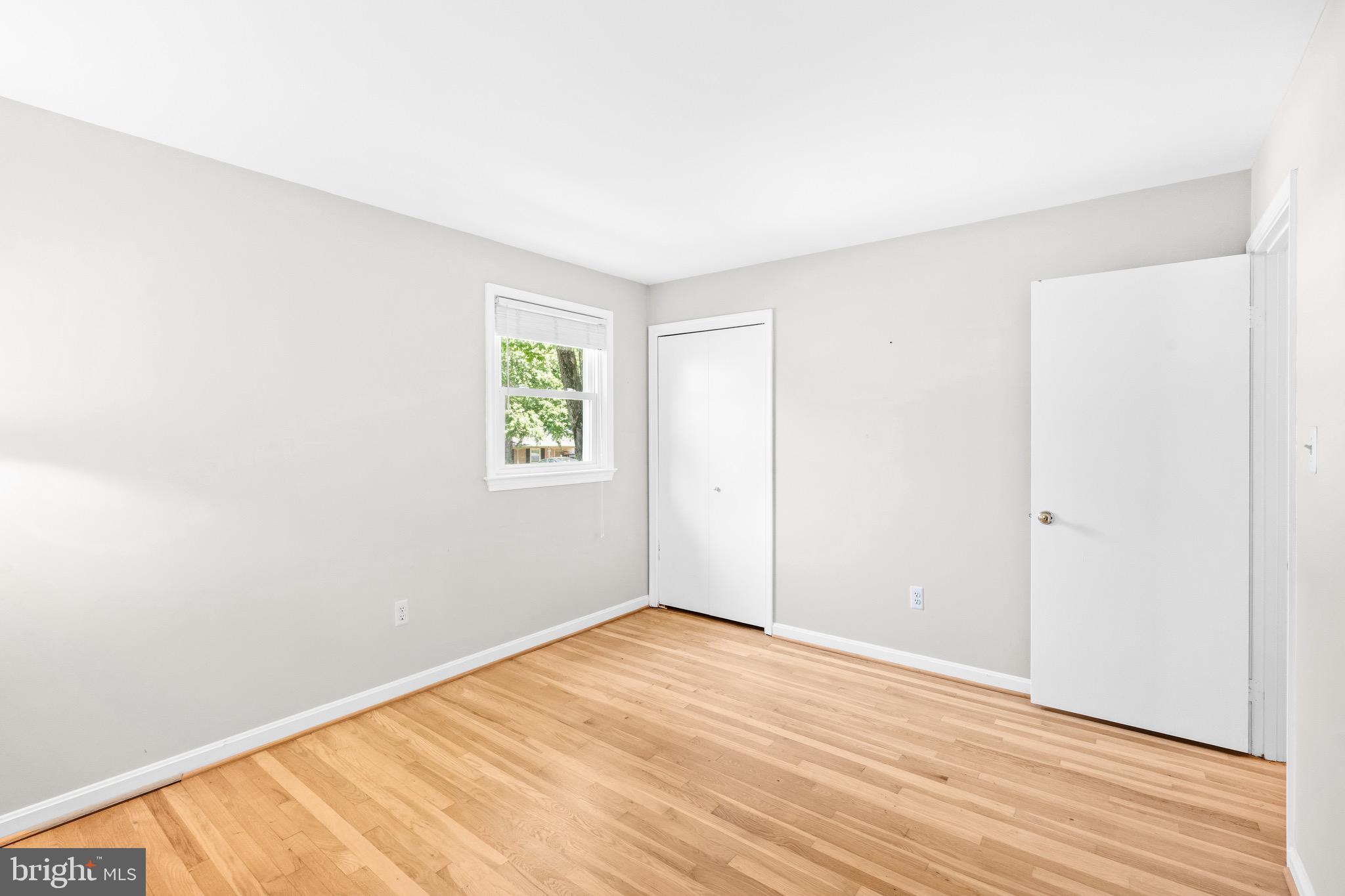 6604 Grey Fox Drive Springfield, VA 22152 - Photo 24 of 46 an empty room with wooden floor and windows