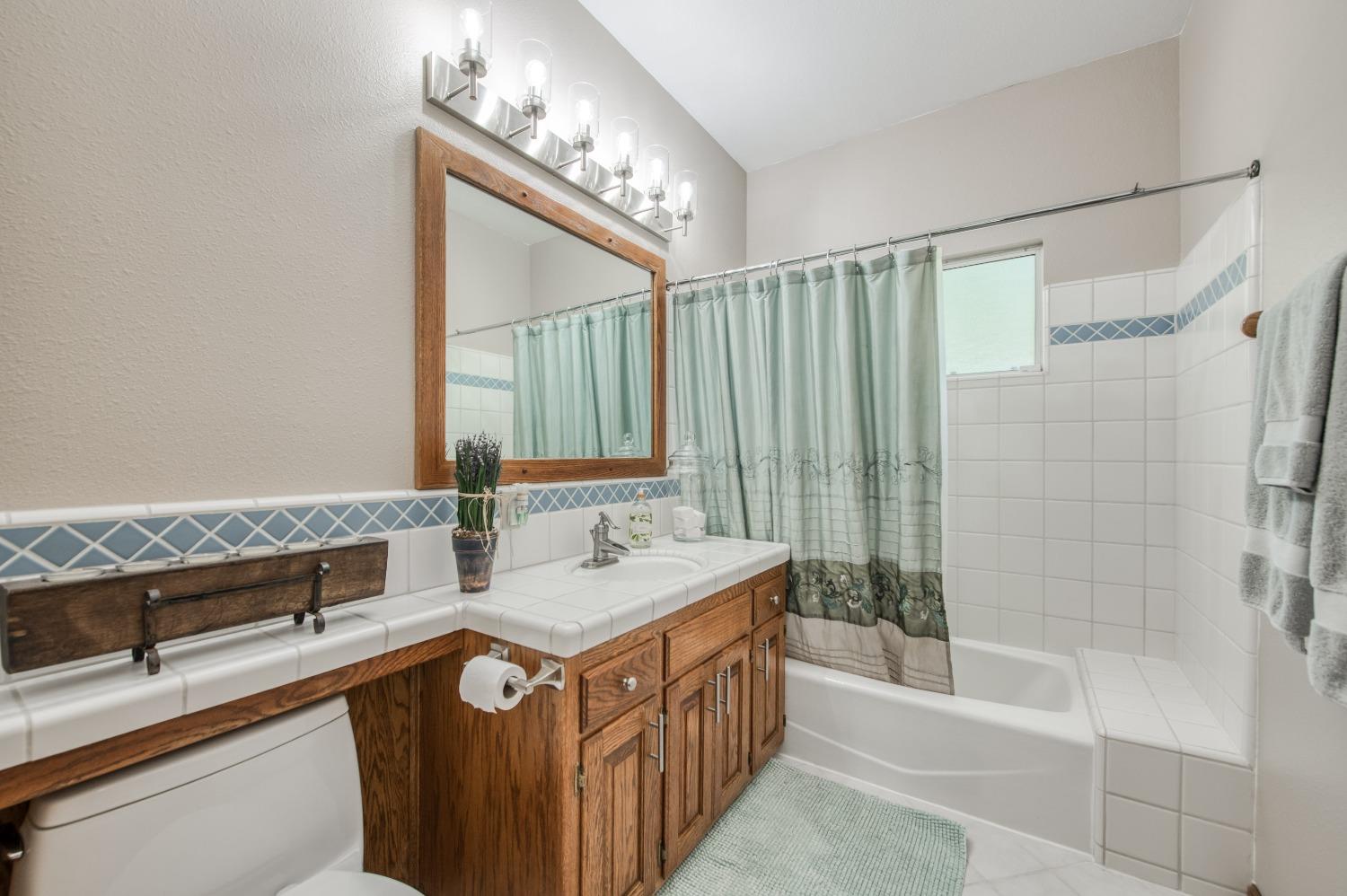 19408 Farallon Road Madera, CA 93638 - Photo 28 of 62 a bathroom with a double vanity sink a mirror and a bathtub