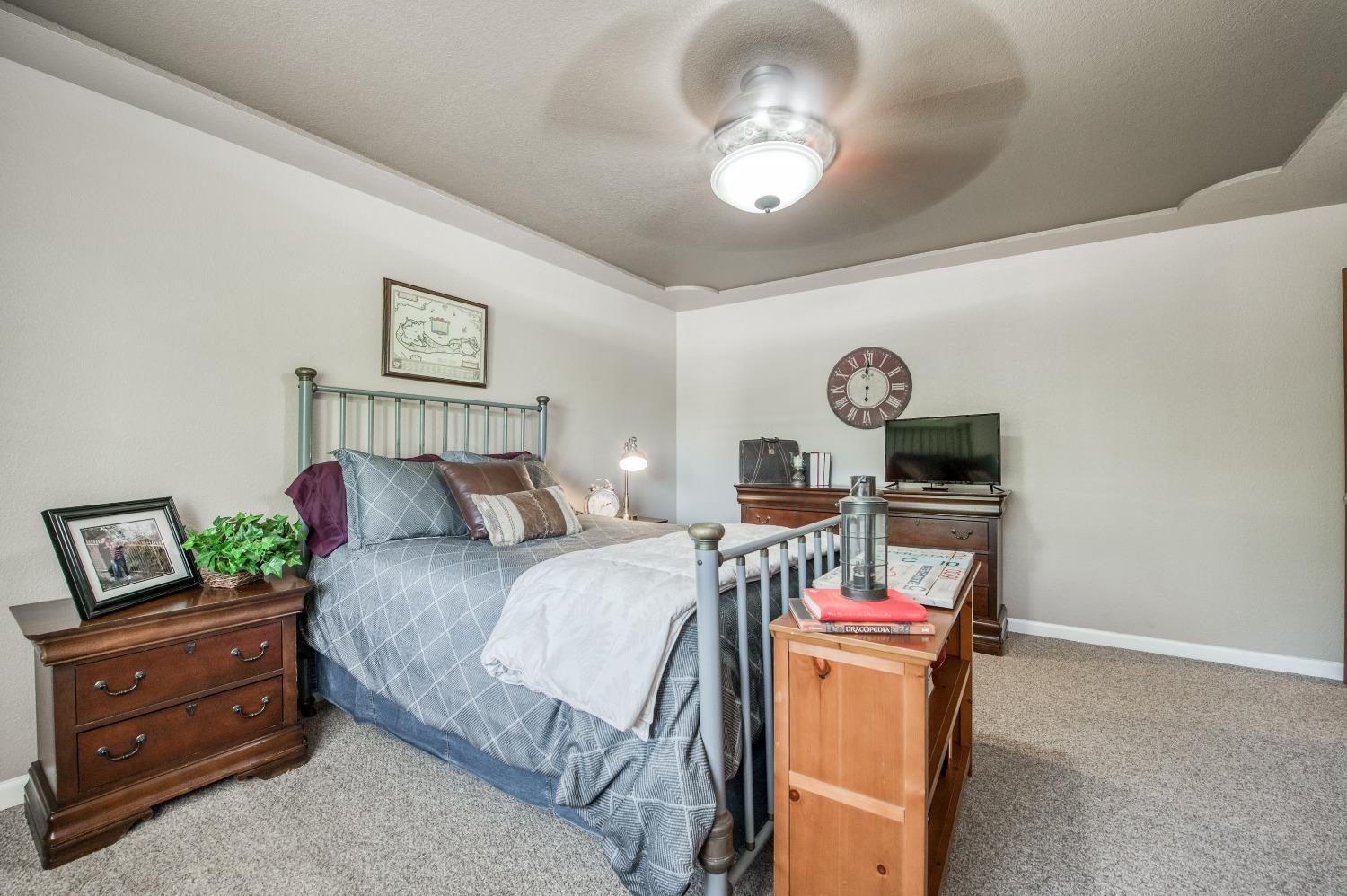 19408 Farallon Road Madera, CA 93638 - Photo 39 of 62 a bed room with a bed and a chandelier