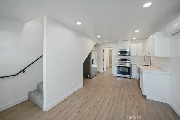 a kitchen with stove and wooden floor