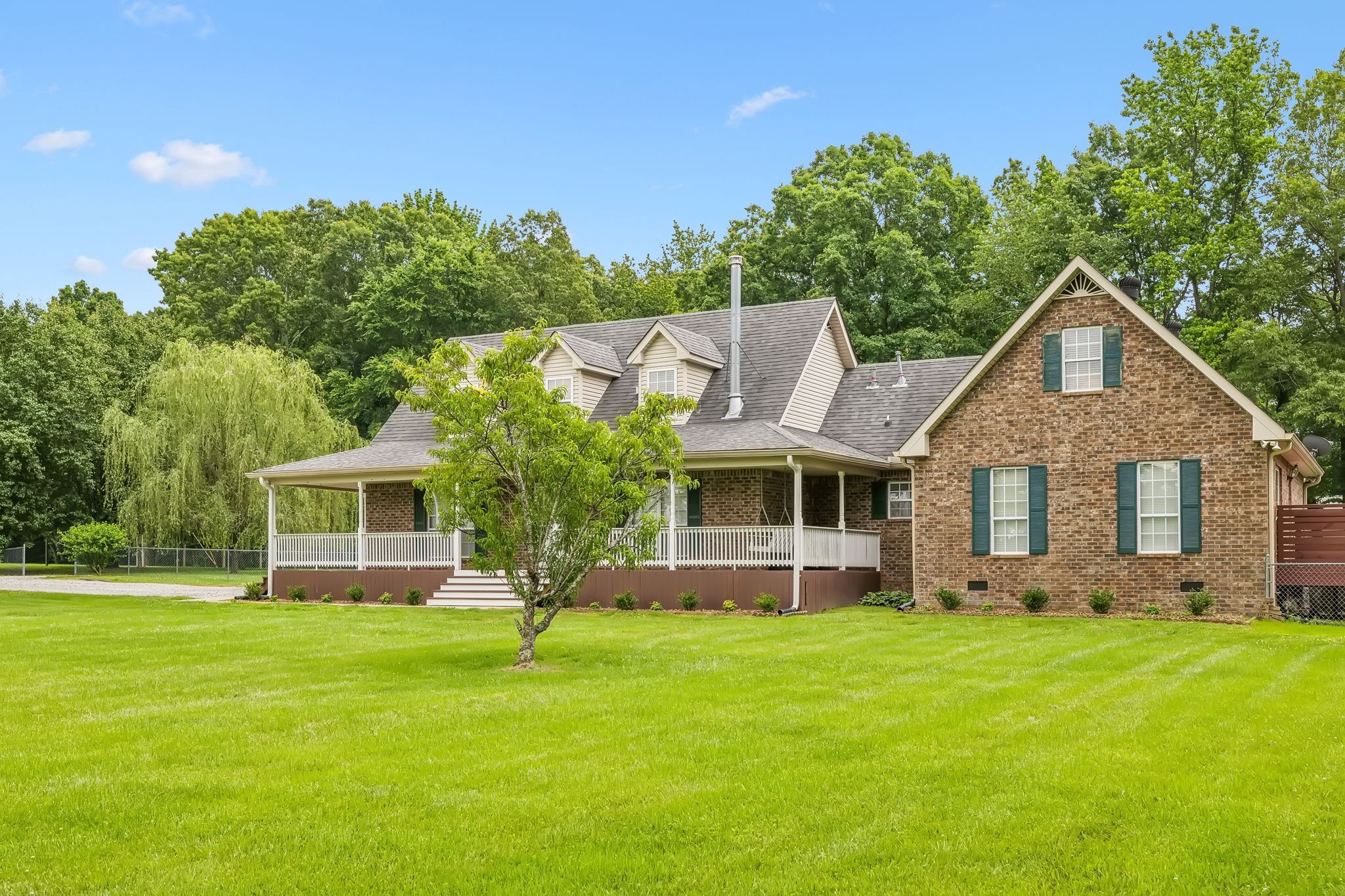 a front view of house with yard and green space
