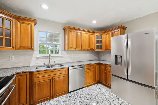 a kitchen with stainless steel appliances granite countertop a refrigerator sink and cabinets