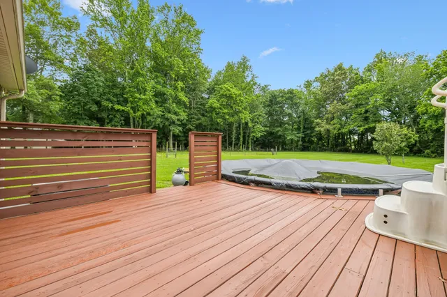 a backyard of a house with lawn chairs and a tree