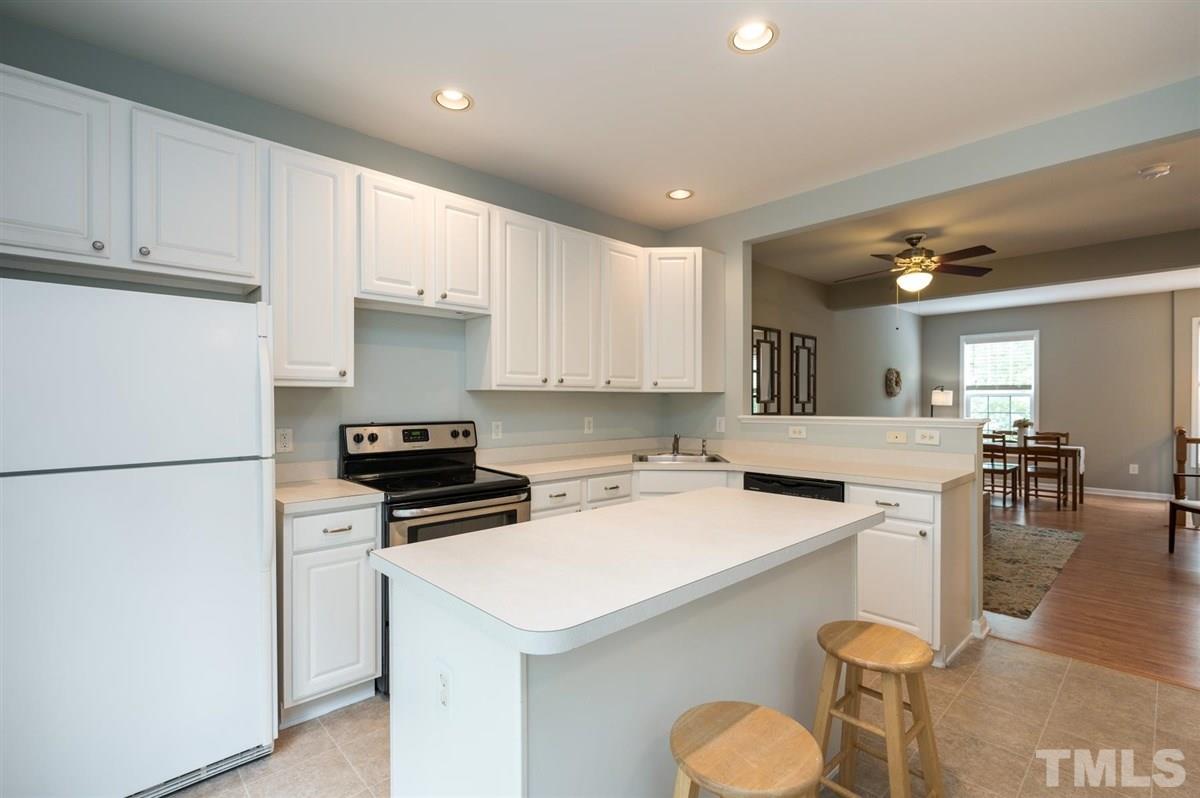5414 Echo Ridge Road Raleigh, NC 27612 - Photo 8 of 22 a kitchen with a sink a stove and chairs