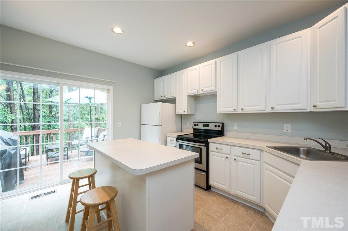 5414 Echo Ridge Road Raleigh, NC 27612 - Photo 9 of 22 a kitchen with a sink stove and white cabinets