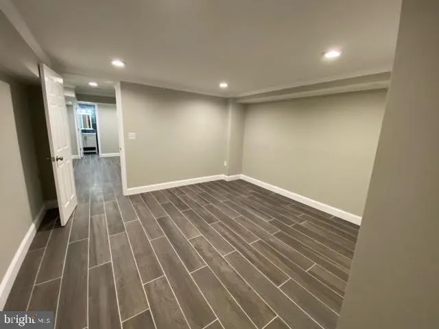 an empty room with wooden floor and a bathroom